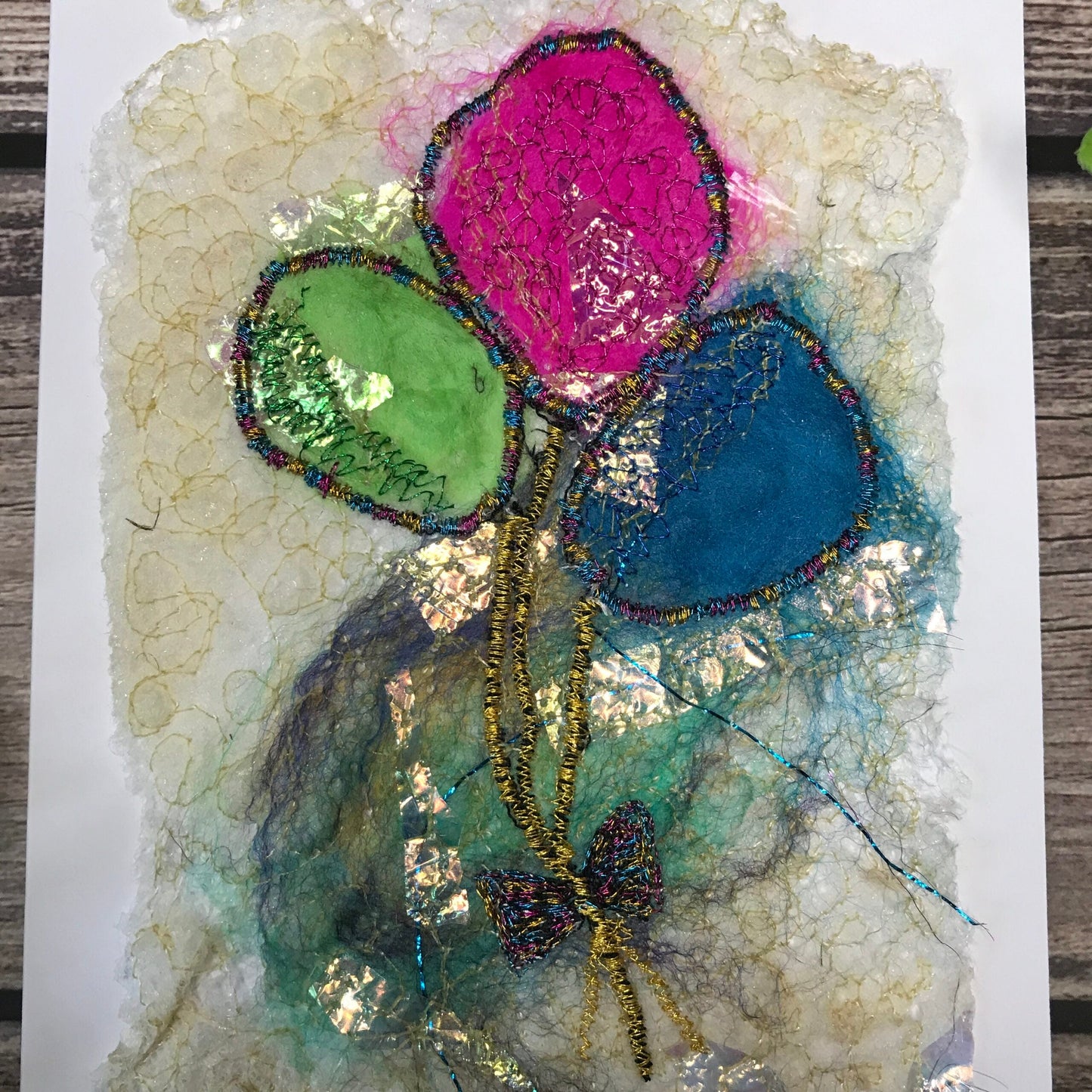 Carte de vœux avec jolis ballons verts, roses et bleus brodée sur la laine