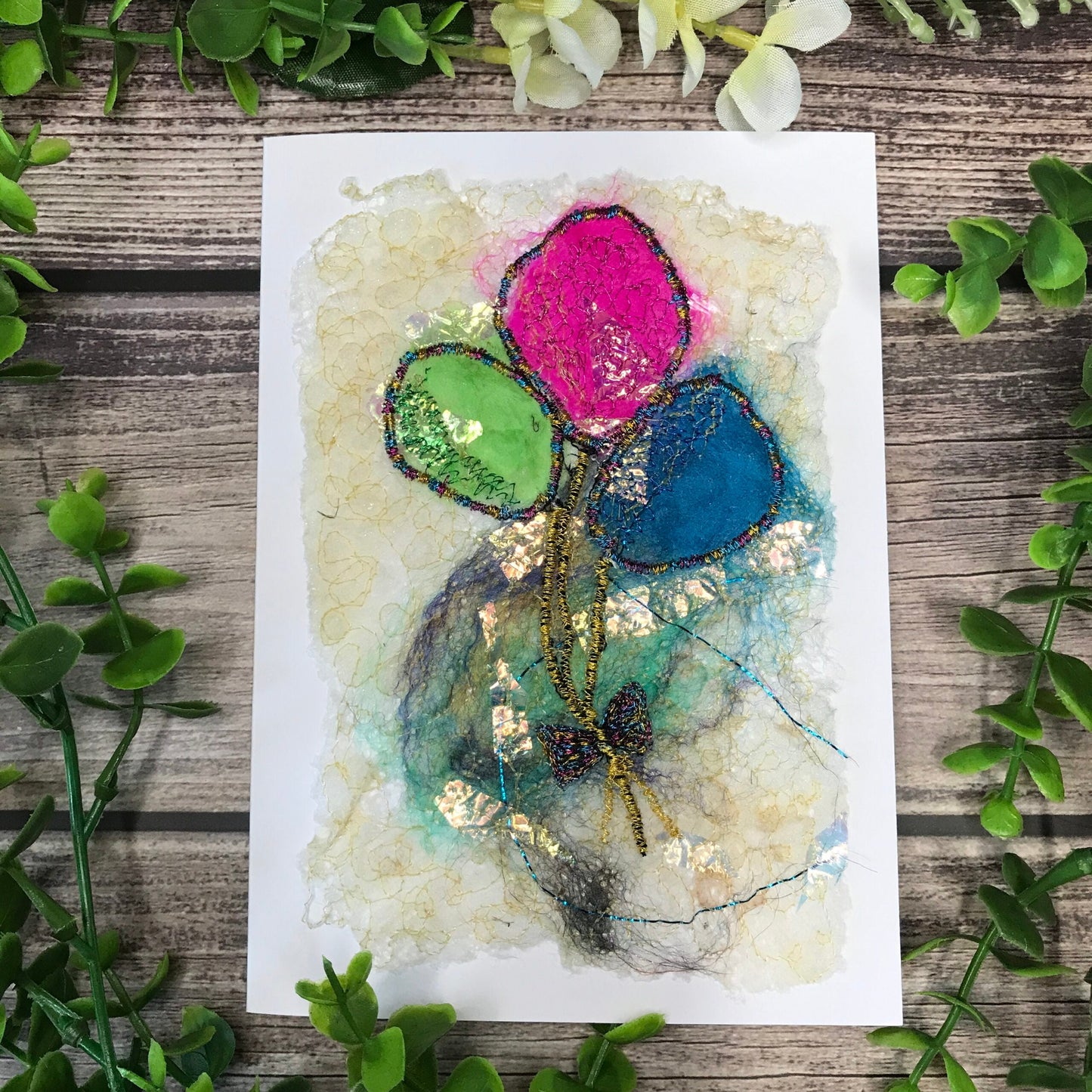 Carte de vœux avec jolis ballons verts, roses et bleus brodée sur la laine